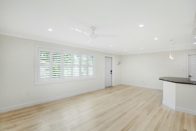 unfurnished living room featuring ornamental molding, ceiling fan, and light hardwood / wood-style flooring