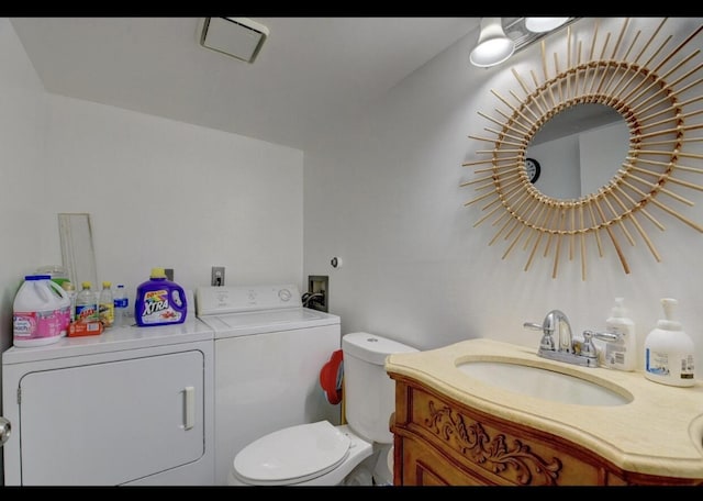 bathroom with vanity, toilet, and washer and dryer