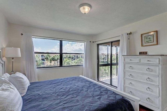 bedroom with access to outside and a textured ceiling