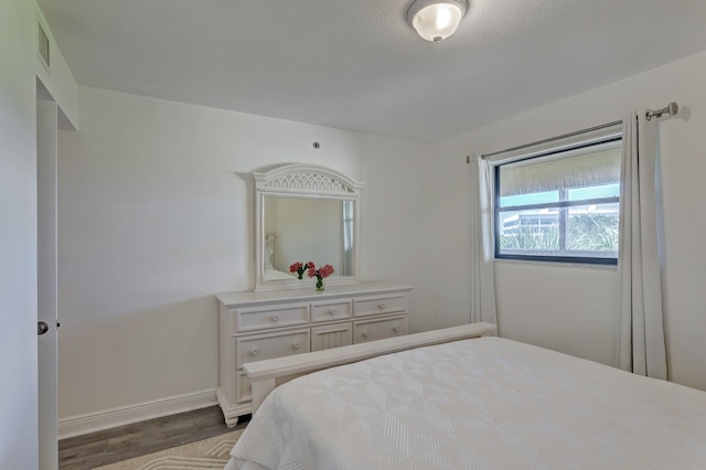 bedroom featuring wood-type flooring and a textured ceiling