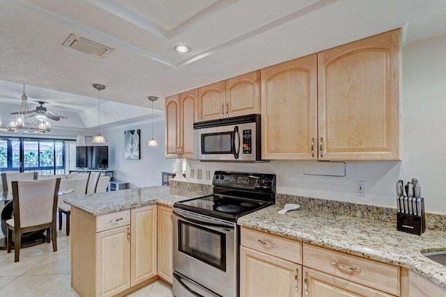 kitchen with appliances with stainless steel finishes, a tray ceiling, and light brown cabinets