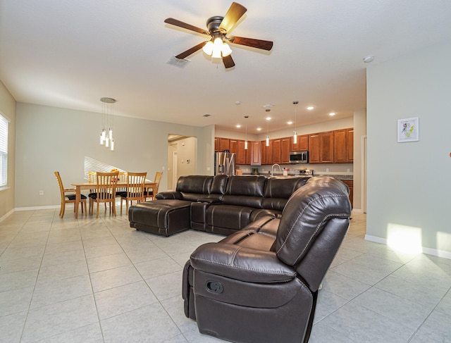 living room with sink, light tile patterned floors, and ceiling fan