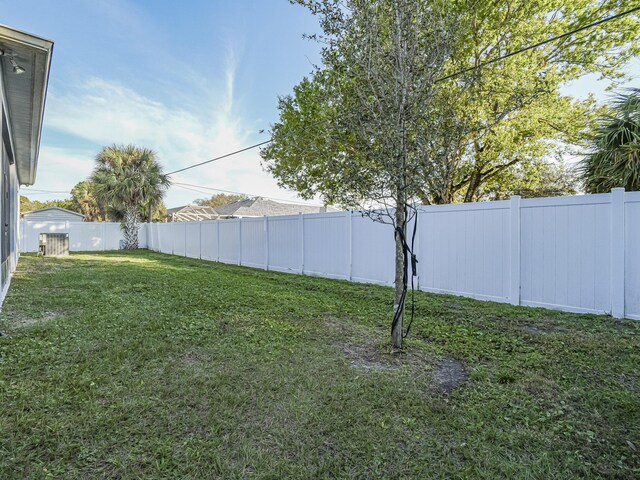 rear view of house featuring central AC and a yard