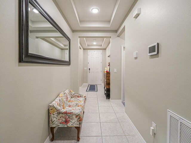 tiled entrance foyer featuring a raised ceiling