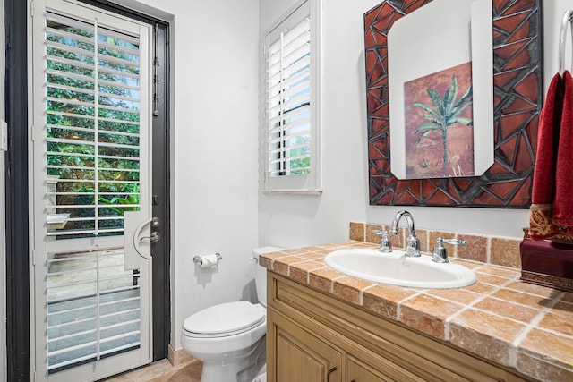 bathroom with vanity, a wealth of natural light, and toilet