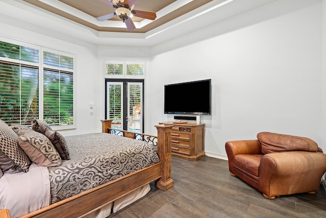 bedroom featuring ceiling fan, wood-type flooring, a raised ceiling, access to outside, and french doors