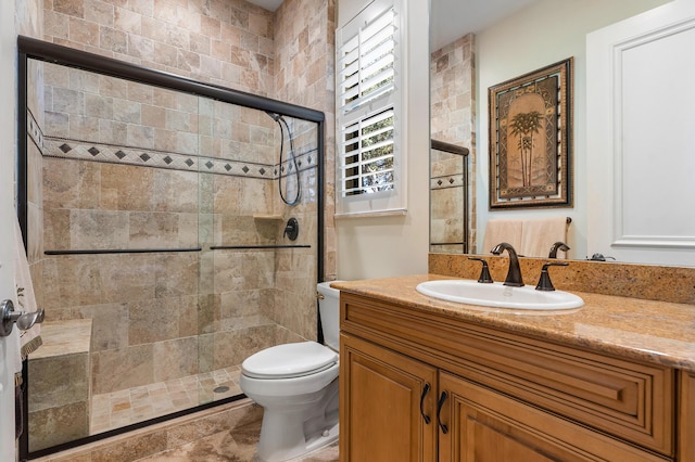 bathroom featuring vanity, toilet, and a shower with door