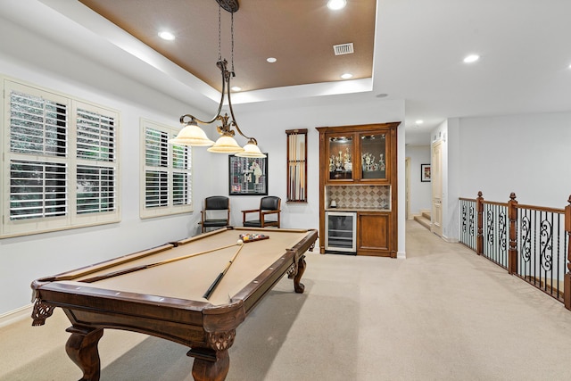 playroom featuring billiards, beverage cooler, bar, light colored carpet, and a raised ceiling