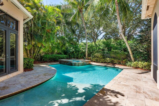 view of swimming pool with a patio and french doors