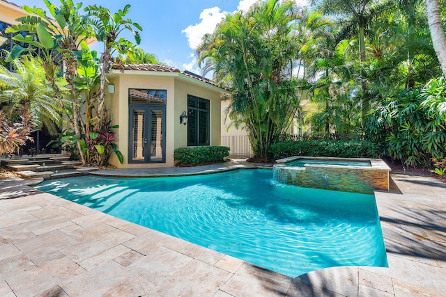 view of swimming pool featuring an in ground hot tub, a patio, an outdoor structure, and french doors