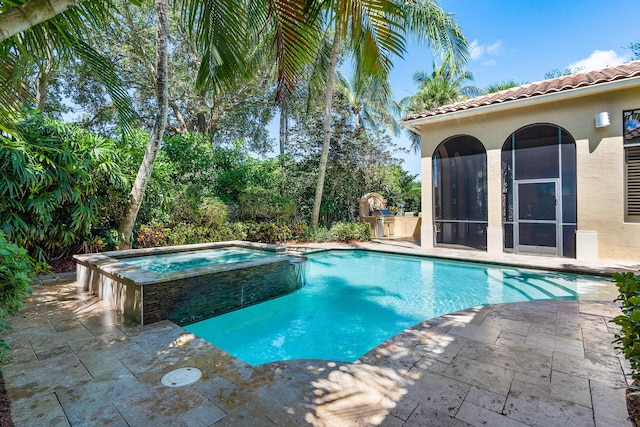 view of pool featuring exterior kitchen, an in ground hot tub, and a patio area