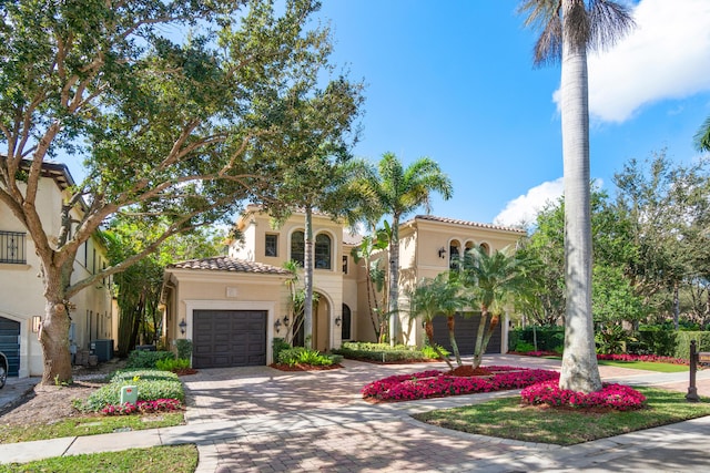 mediterranean / spanish house featuring central AC and a garage