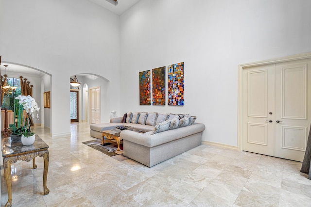 living room with a high ceiling and an inviting chandelier