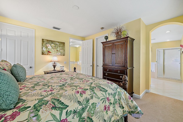 bedroom featuring light carpet and a textured ceiling