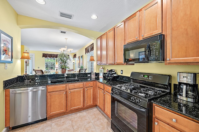 kitchen with dark stone countertops, sink, kitchen peninsula, and black appliances