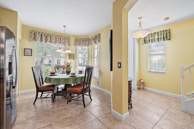 dining room featuring light tile patterned flooring and a textured ceiling