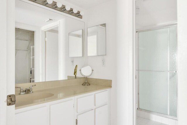 bathroom featuring toilet, vanity, and a shower with shower door