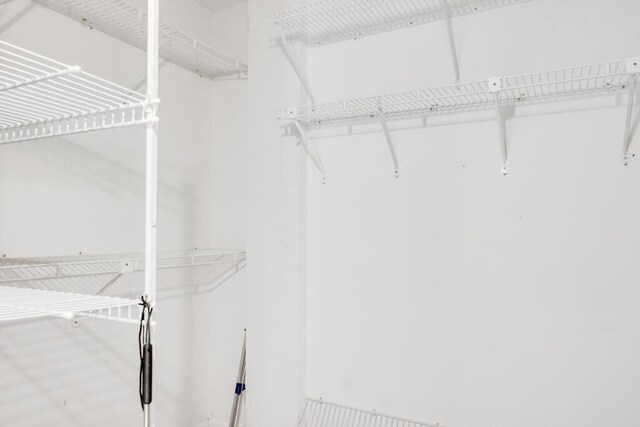 hallway featuring stacked washer / drying machine and light tile patterned floors