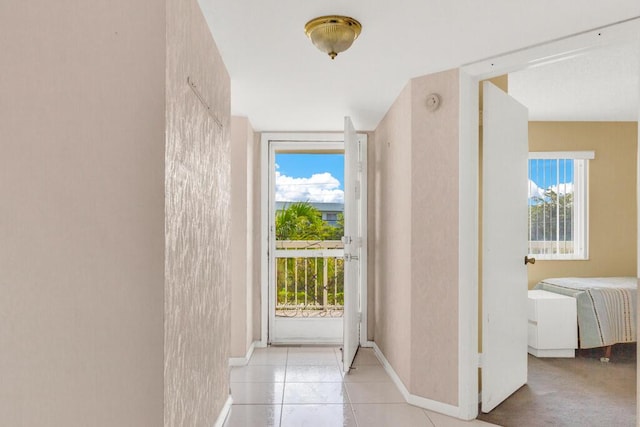 entryway with a wealth of natural light, baseboards, and light tile patterned floors