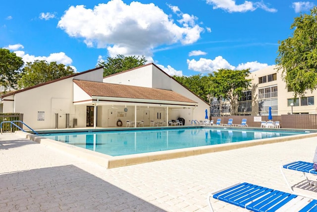 community pool featuring fence and a patio