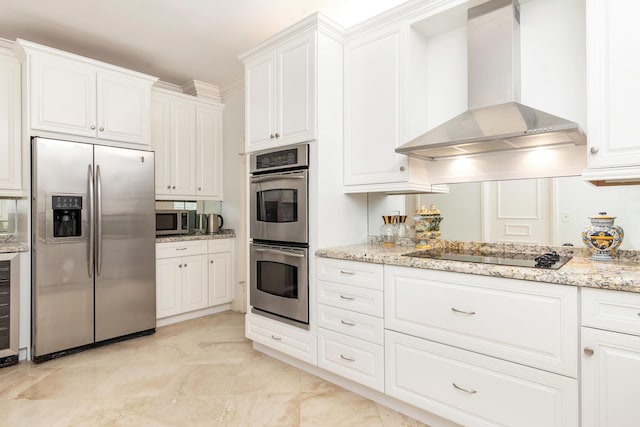 kitchen with wall chimney range hood, white cabinetry, stainless steel appliances, and light stone counters