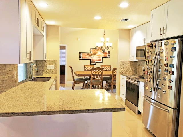 kitchen featuring white cabinetry, sink, kitchen peninsula, and appliances with stainless steel finishes