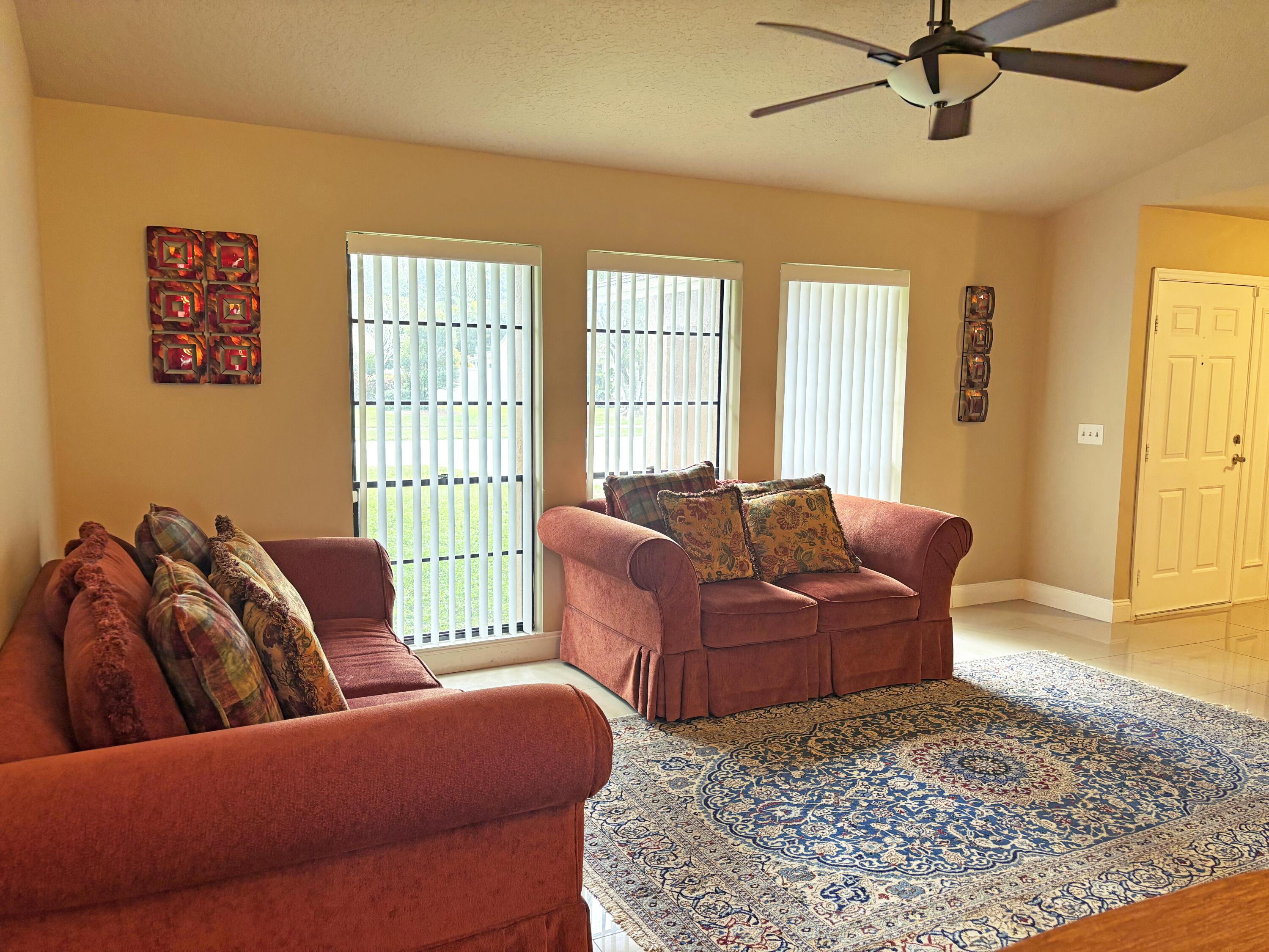 living room with tile patterned flooring and ceiling fan