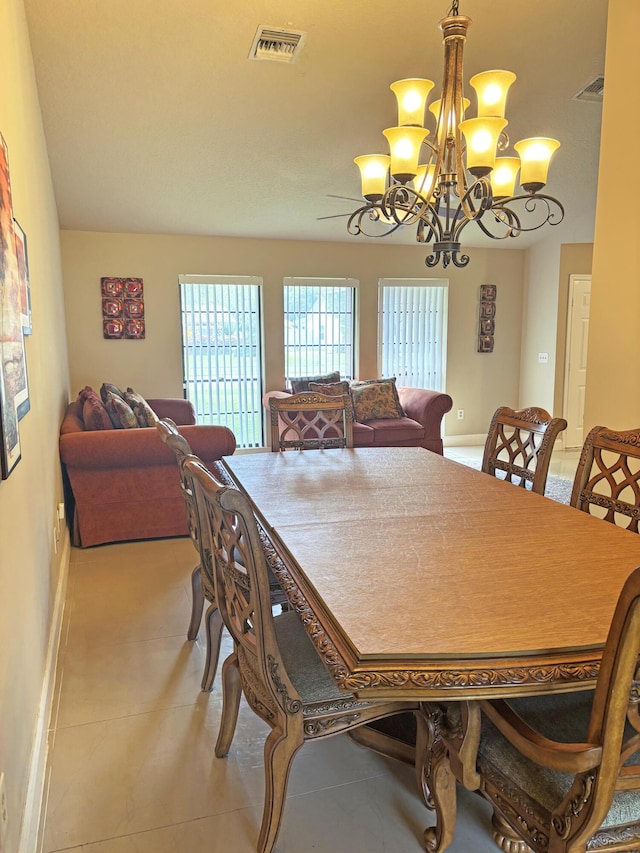 dining area featuring an inviting chandelier and light tile patterned floors