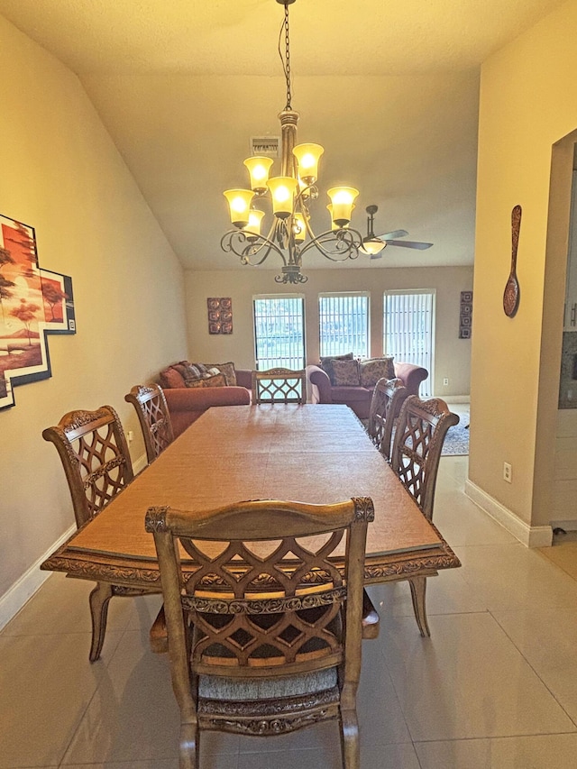 tiled dining room featuring a notable chandelier and vaulted ceiling