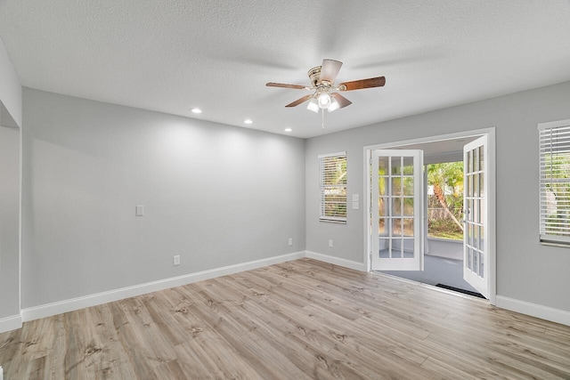 empty room featuring ceiling fan, light hardwood / wood-style floors, and a textured ceiling