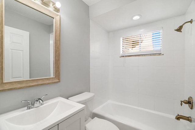 full bathroom with vanity, tiled shower / bath, and toilet