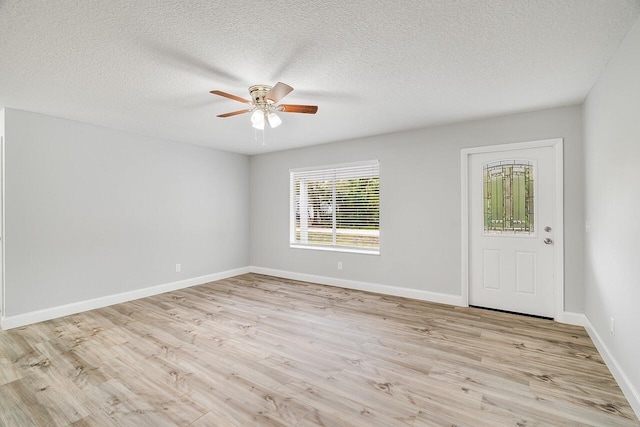 empty room featuring ceiling fan, a textured ceiling, and light hardwood / wood-style floors