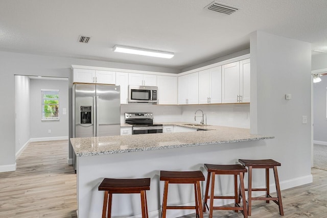 kitchen featuring white cabinetry, stainless steel appliances, sink, and backsplash