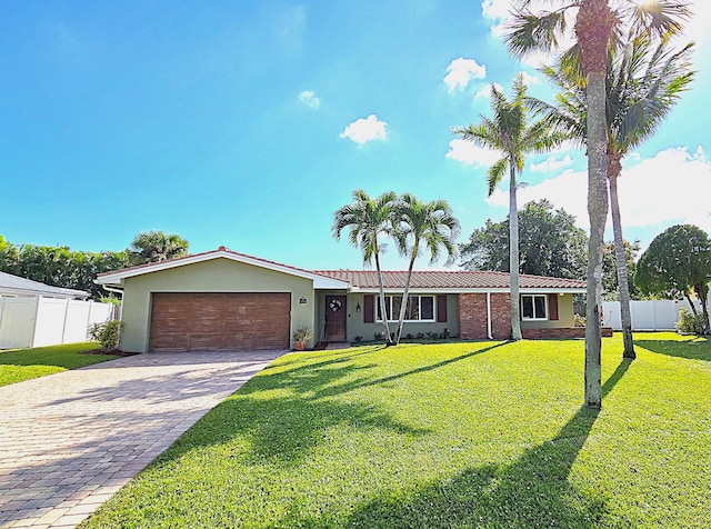 single story home featuring a garage and a front yard