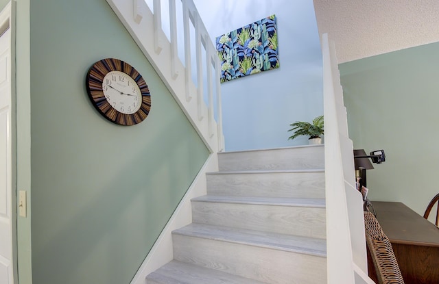 stairway featuring a textured ceiling