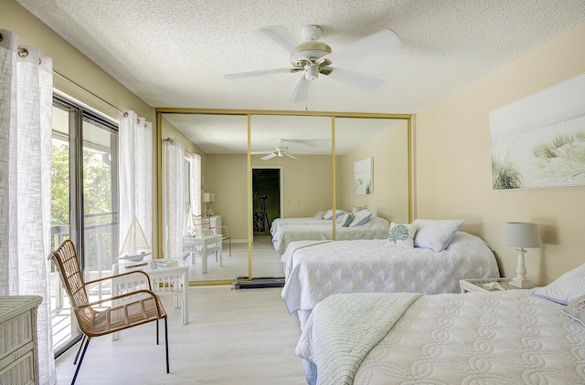 bedroom featuring ceiling fan, light hardwood / wood-style floors, a closet, and a textured ceiling