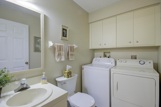 bathroom with vanity, independent washer and dryer, and toilet