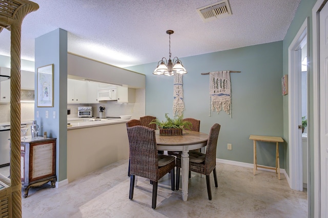 dining space featuring a notable chandelier and a textured ceiling