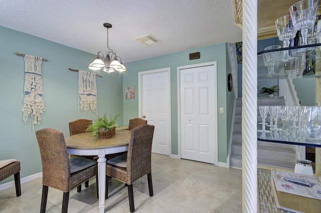 dining space featuring a chandelier and a textured ceiling