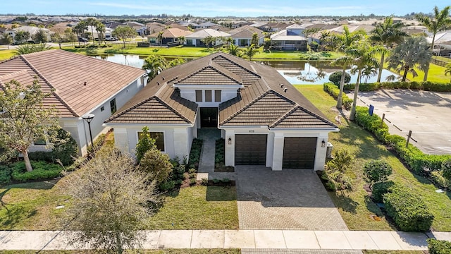 view of front of property with a garage and a water view