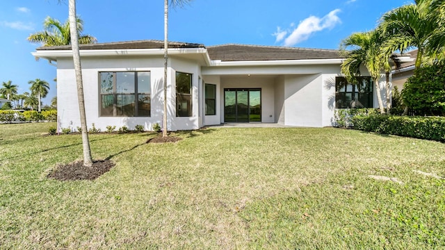 back of house featuring a lawn and a patio