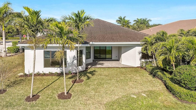 rear view of property with a yard and a patio area