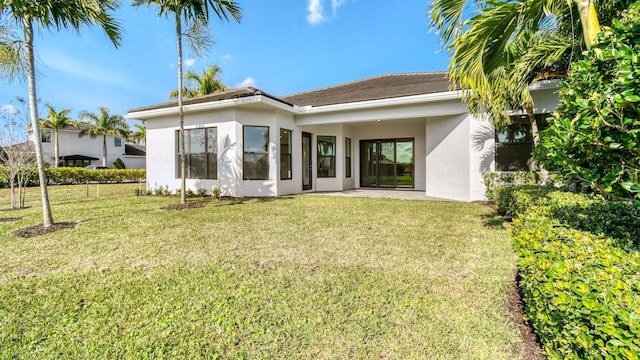 back of property with a patio area and a lawn