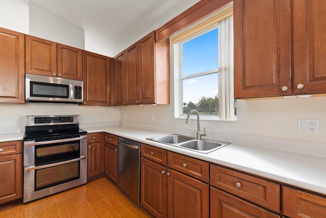 kitchen with sink, light hardwood / wood-style floors, and appliances with stainless steel finishes