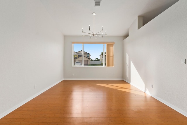 unfurnished dining area featuring a notable chandelier and light wood-type flooring