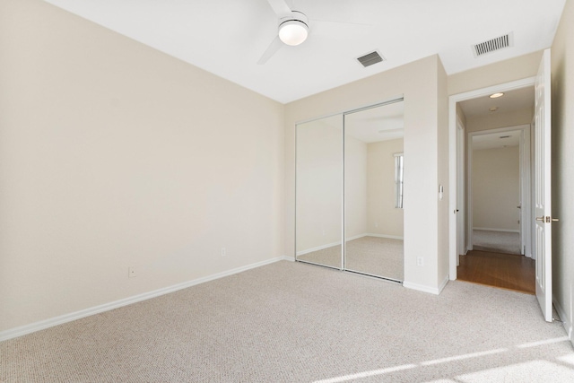 unfurnished bedroom with ceiling fan, carpet, and a closet