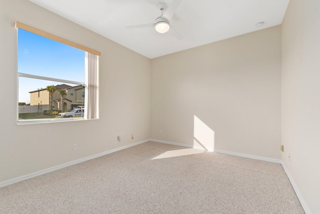 carpeted spare room featuring ceiling fan