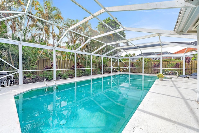 view of swimming pool with glass enclosure, a fenced in pool, and a fenced backyard