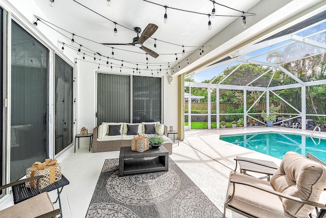 view of swimming pool featuring a patio area, outdoor lounge area, ceiling fan, and glass enclosure