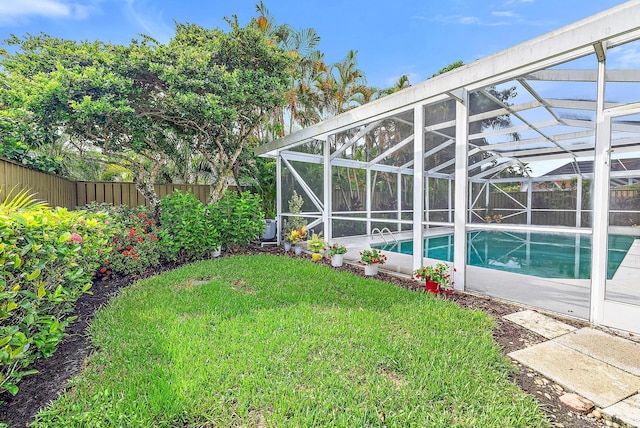 view of yard with a fenced in pool and glass enclosure